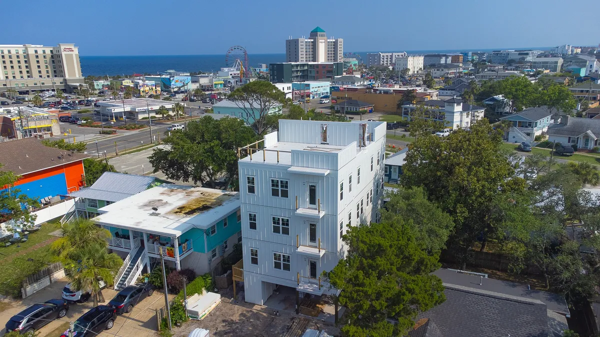 A dynamic exterior shot featuring the building with the ocean in the background and several surrounding attractions visible. The energy of the area comes through with the lively urban and coastal vibe.