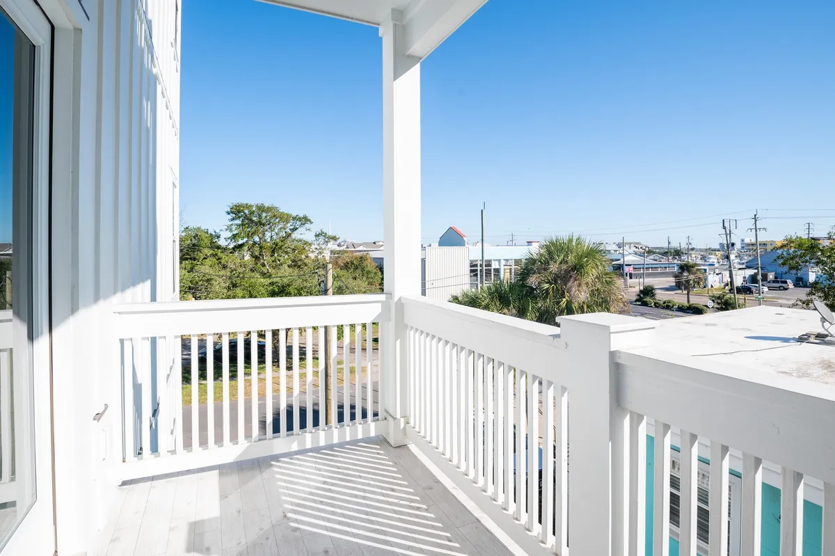 A serene balcony view with a railing overlooking distant trees and surrounding scenery. The atmosphere is peaceful, inviting relaxation and connection to nature.